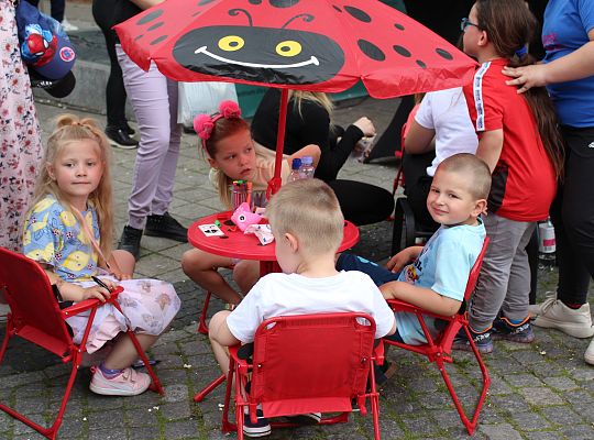 Grafika 29. Dzieci siedzące na krzesełakch przy stoliku